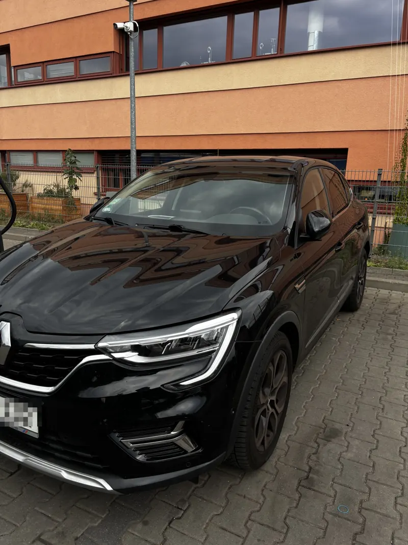 Schwarzer Renault Arkana schräg von vorn nach dem Termin