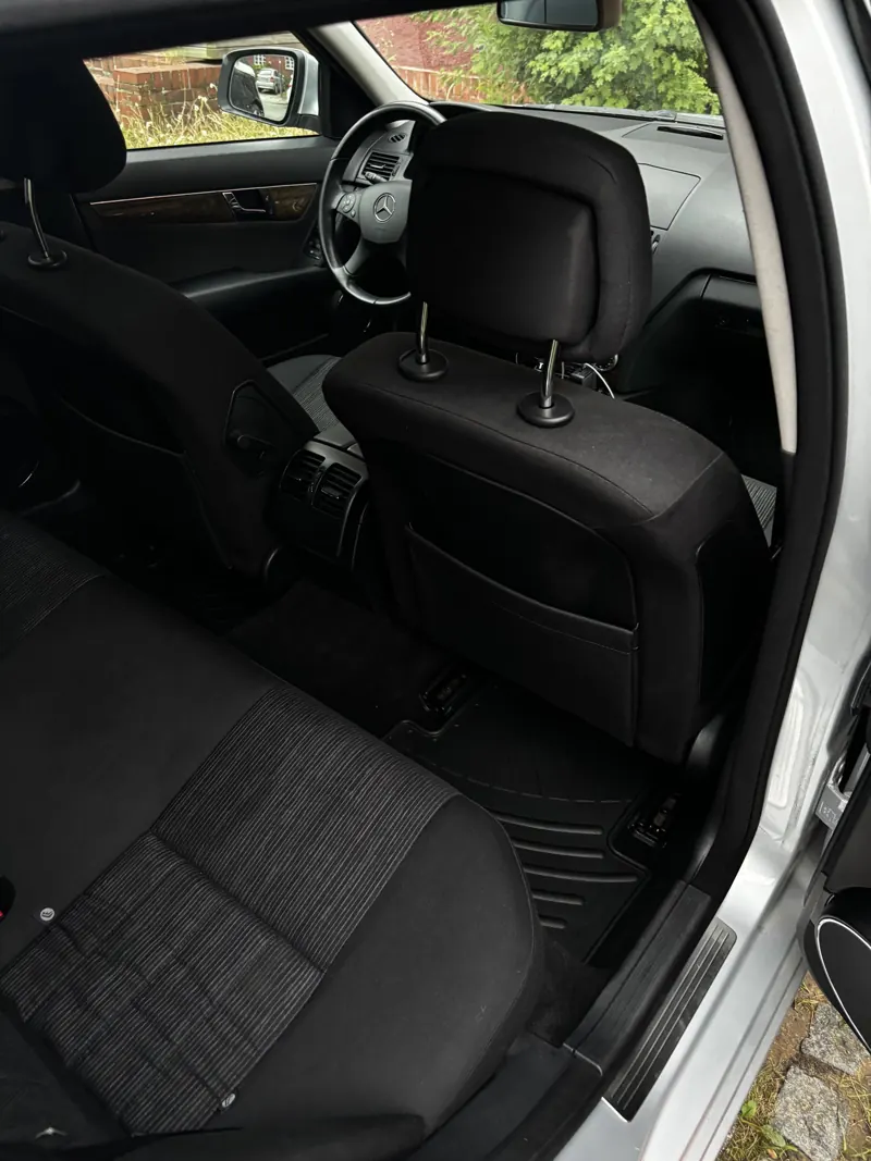 Blick durch die offene Fahrertür auf den gereinigten Sitz einer Mercedes C-Klasse