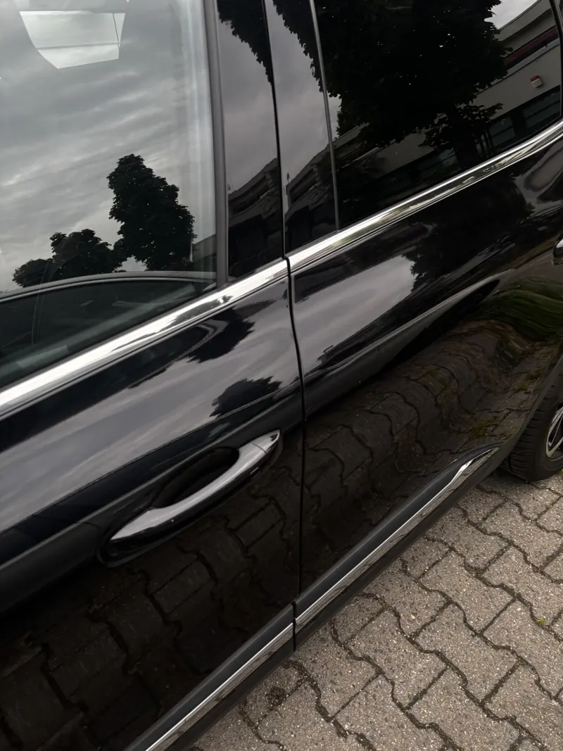 Spiegelnder schwarzer Lack einer Autotür
